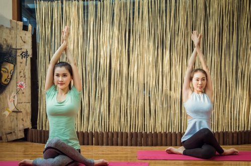2 women doing yoga on purple yoga mat