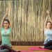 2 women doing yoga on purple yoga mat