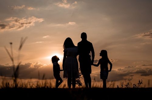 a family standing in a field at sunset